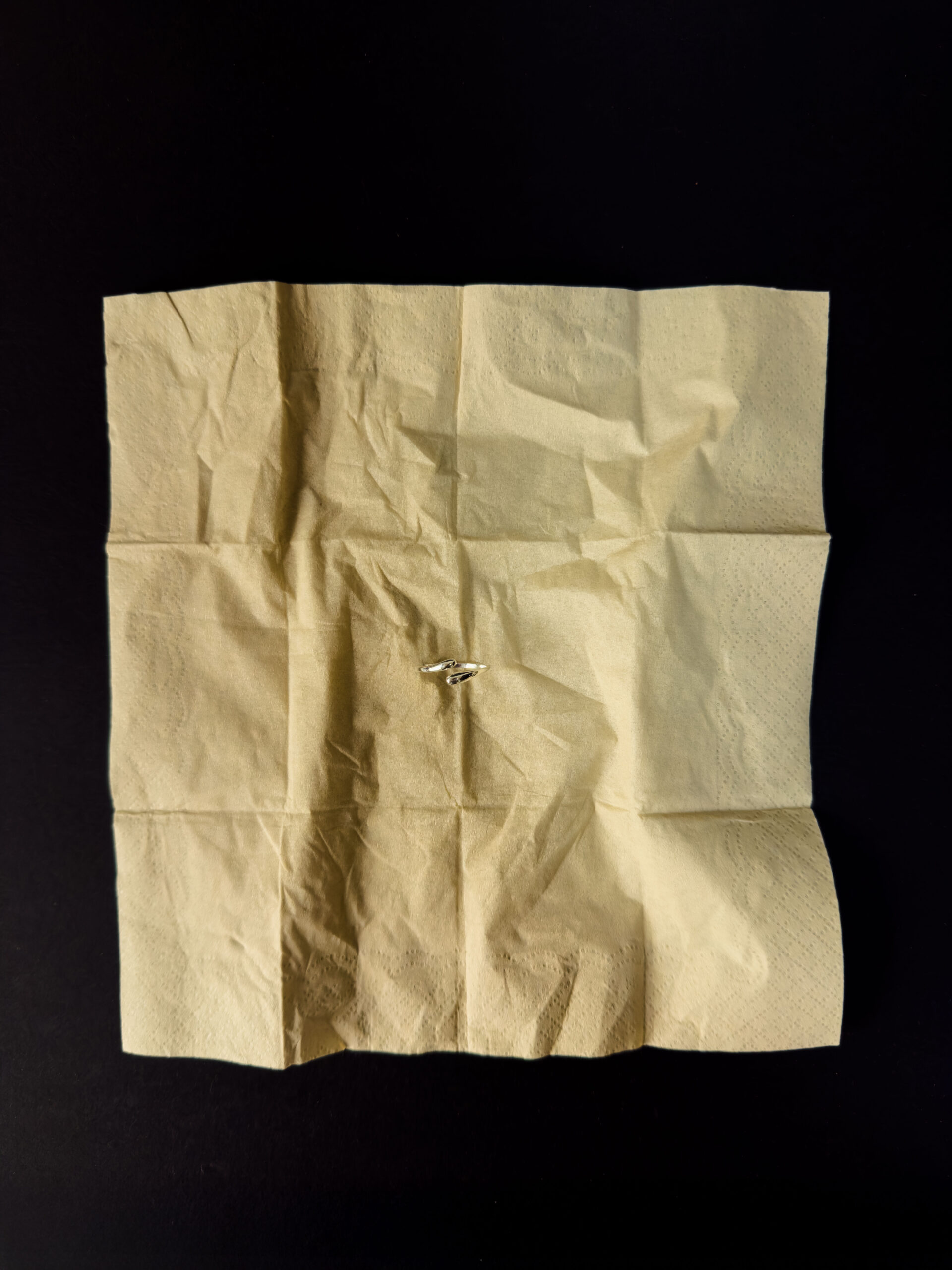 구겨진 베이지 종이 위에 놓인 Twist Arc Ring, 925 실버 데일리 주얼리 실버 반지 제품 이미지