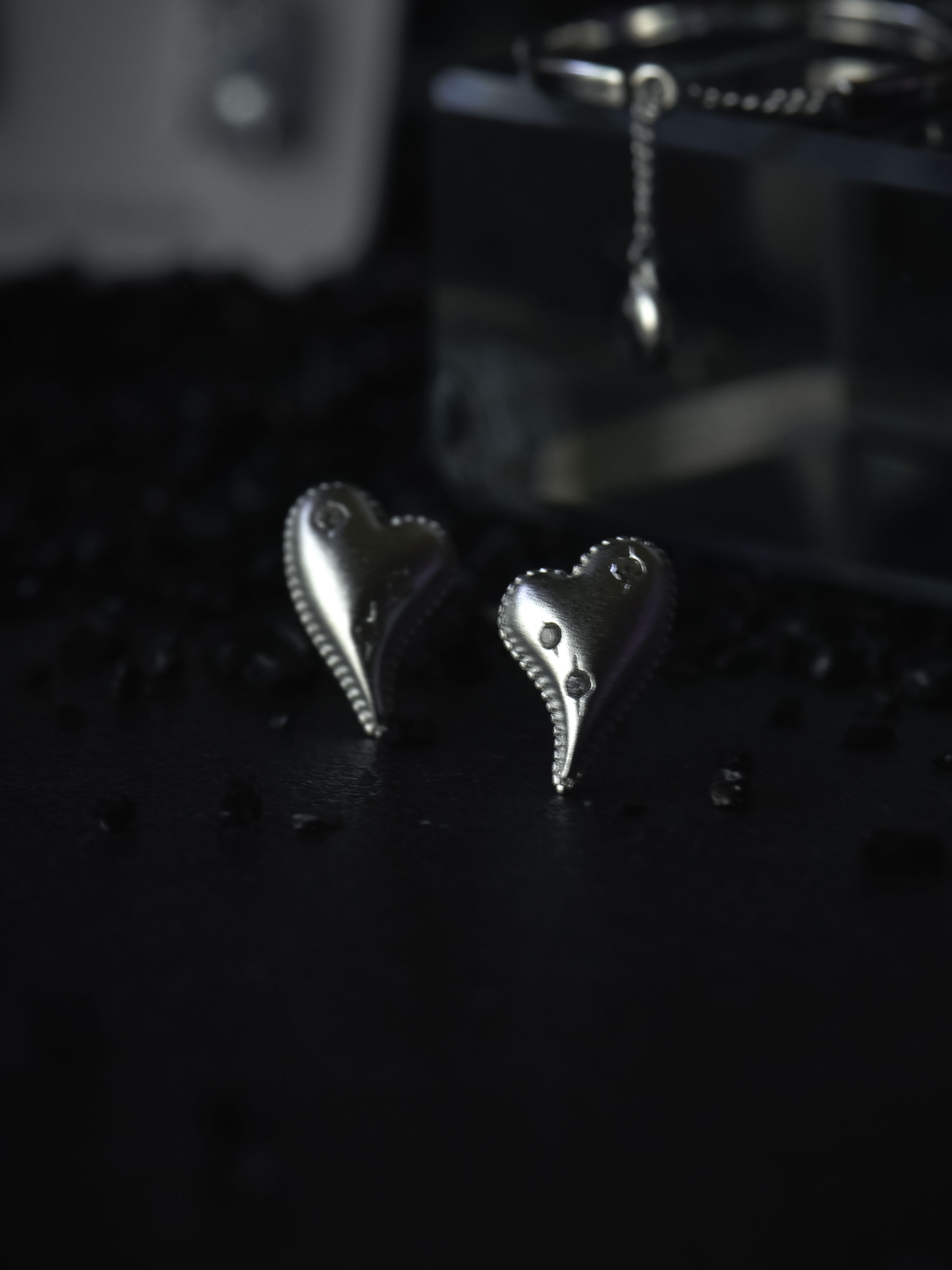 하트 쉐입 위에 배치된 세 개의 큐빅 디테일이 보이는 큐빅 하트 귀걸이 클로즈업