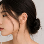 묶은 머리에 실버 이어커프를 착용한 귀 주변 레이어링